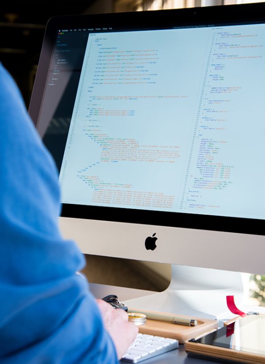 Student looking at code on an iMac.