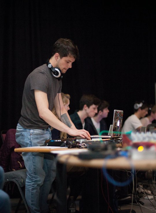 Music students at desk on mixers and laptop