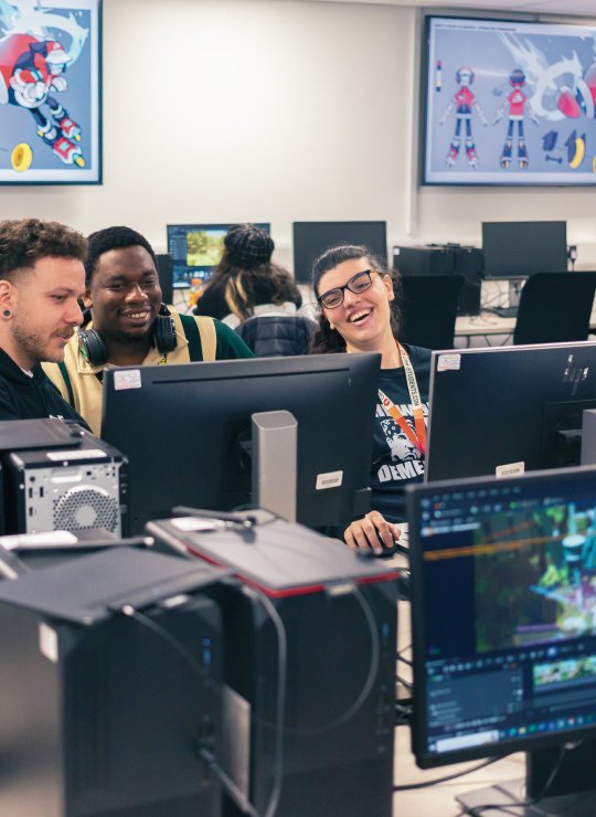 A group of people sat round computer screens