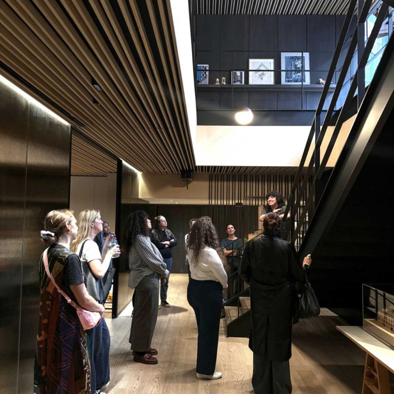 A group stood in a wooden panelled room