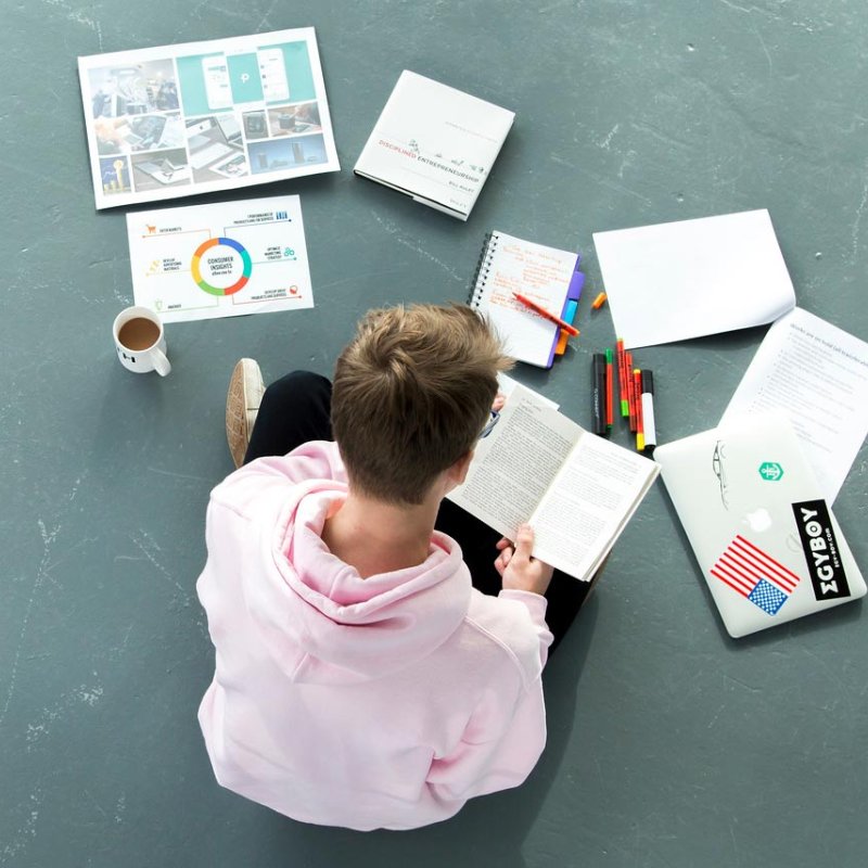 Student sitting on floor working on a project 