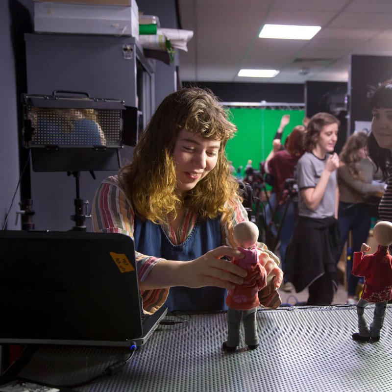 Animation student posing a model figure in a studio