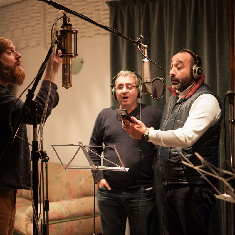 Four people recording a song in a studio