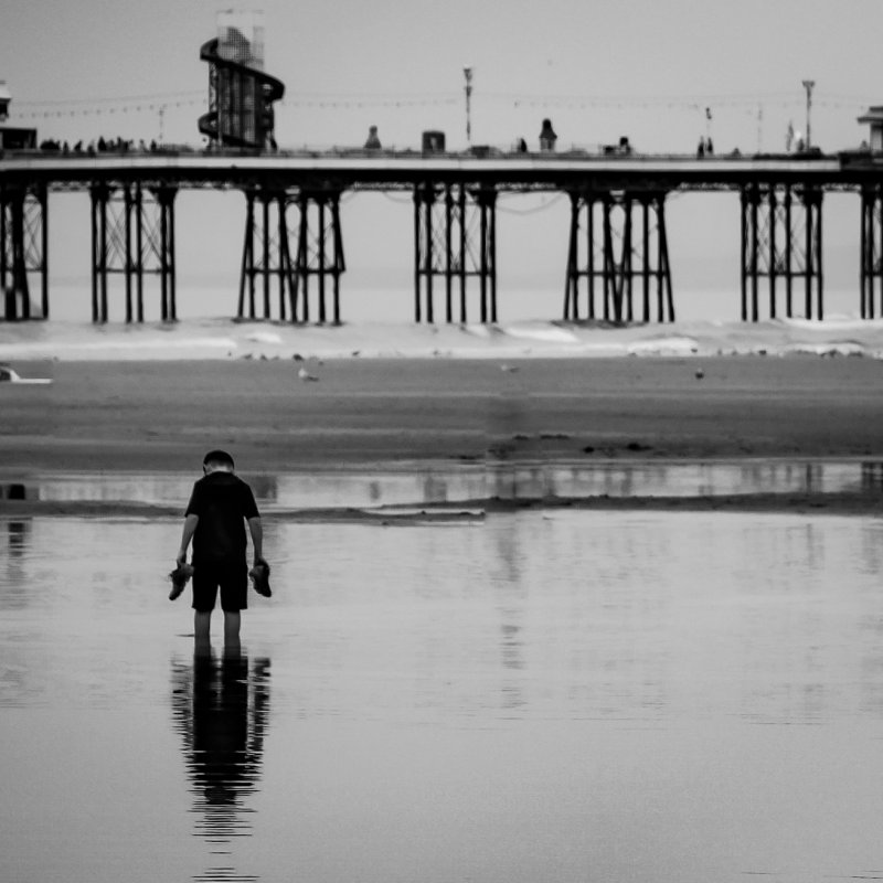 A boy paddling on a beach in Blackpool