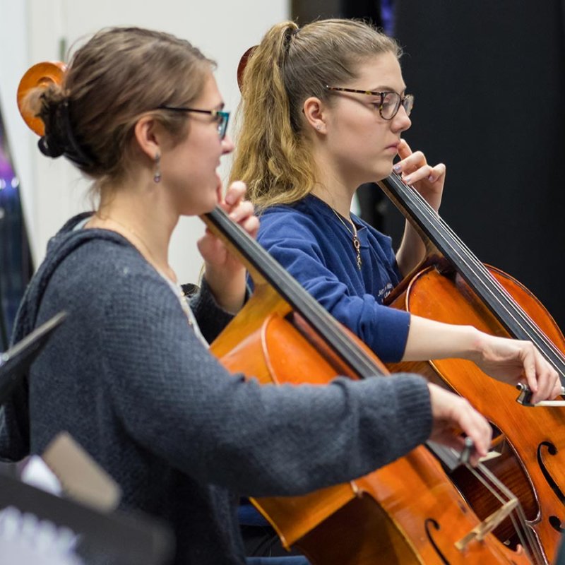 Two female students playing cellos at Falmouth University