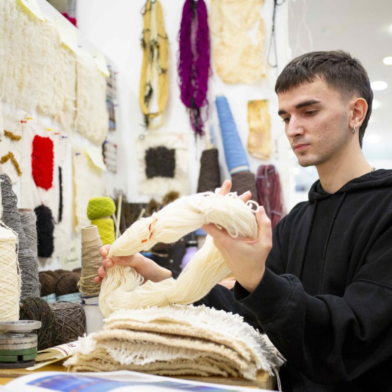 Student handling wool in textile studio