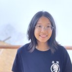 Photo of girl wearing round glasses and navy blue t-shirt