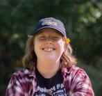 A Falmouth University student wearing a blue baseball cap, smiling