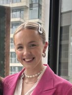 A young woman smiling in a pink jacket