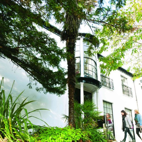 A white building behind greenery