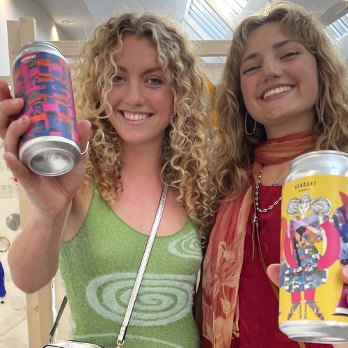 Two people holding Verdant beers with graphic designed labels